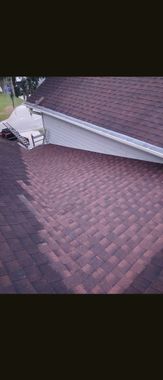 Steep shingled roof with damaged siding and debris near a chimney or vent opening