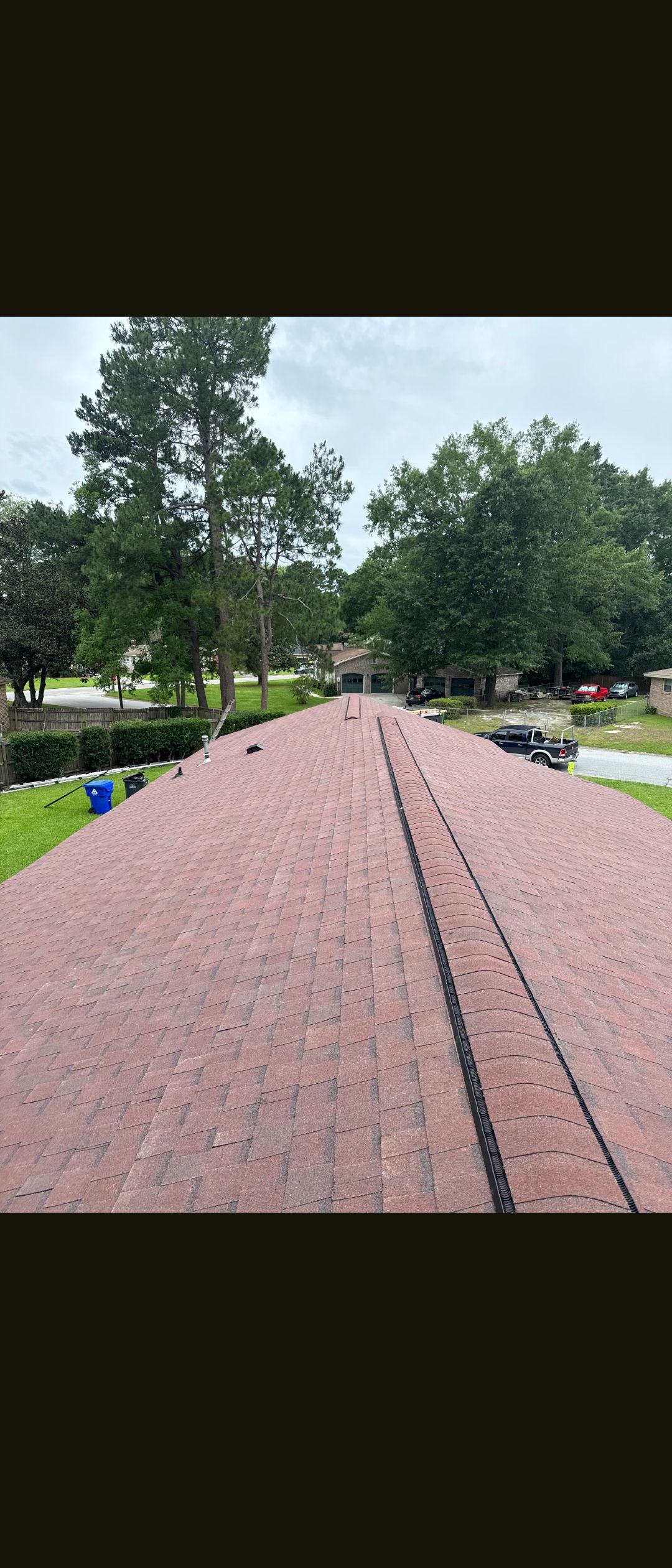 Red brick walkway leading through a green park with trees and a grassy lawn.