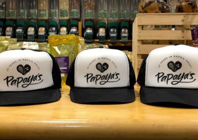 Three white and black mesh trucker hats featuring the