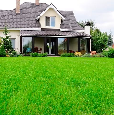 Suburban house with a gray roof and large green lawn in front