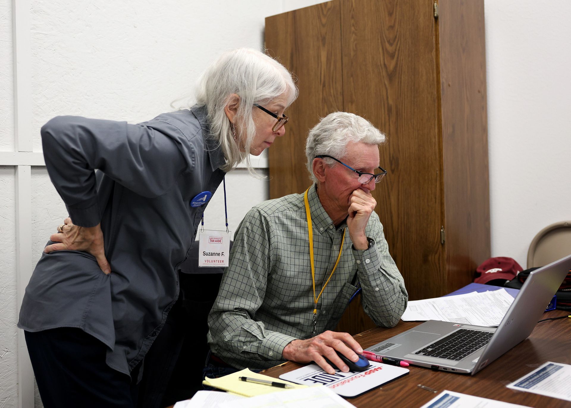 two RSVP volunteers looking at a document on a laptop