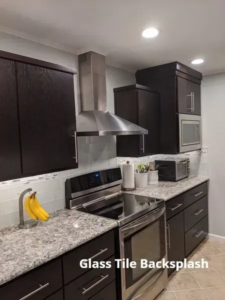 Modern kitchen with dark cabinets, stainless appliances, granite counters, and a glass tile backsplash