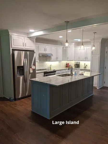 Modern white kitchen with stainless steel appliances and a large blue island