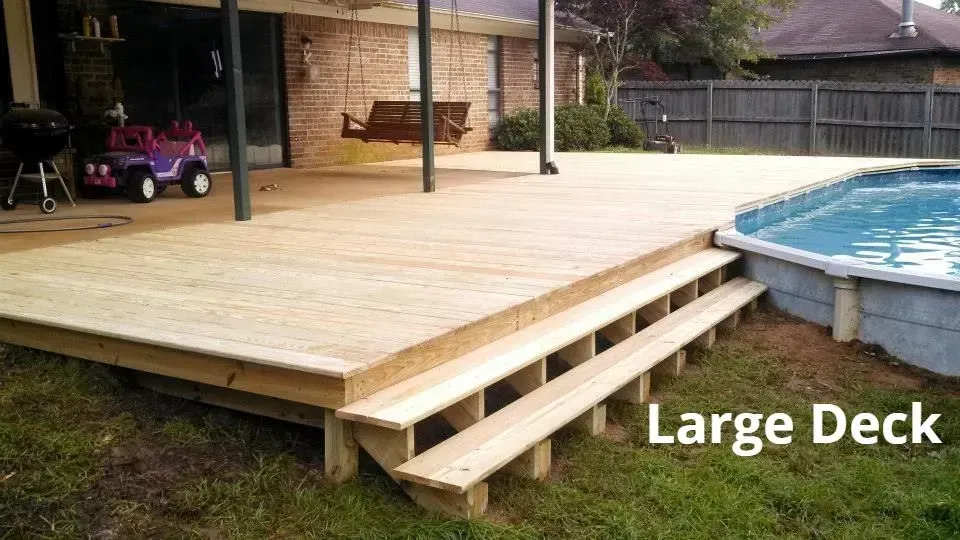 Large wooden deck beside a swimming pool with steps and covered seating area