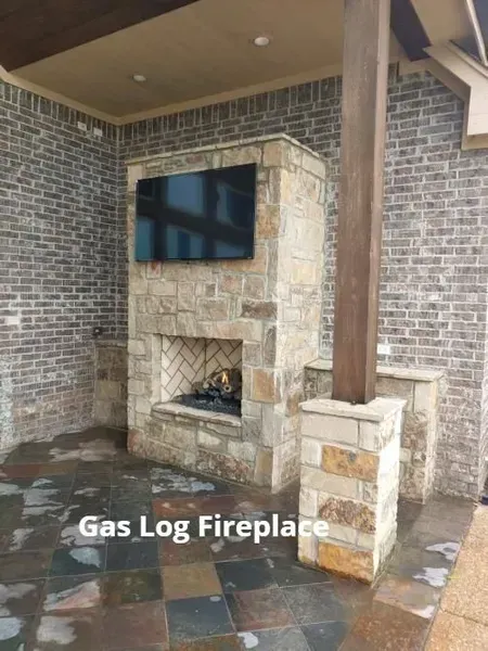 Covered patio with stone gas log fireplace and wall-mounted TV on tiled floor