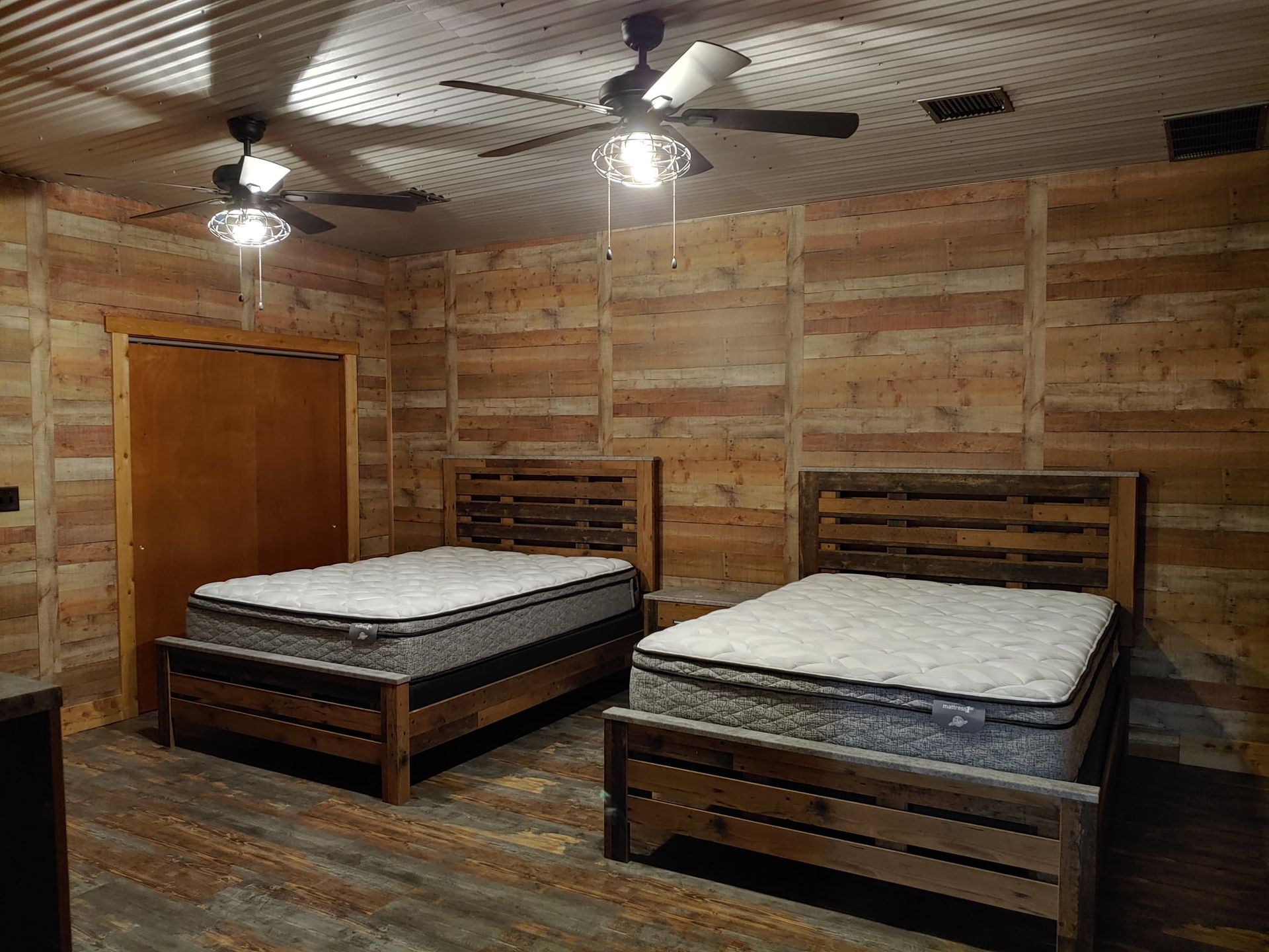 A bedroom with two beds and a ceiling fan.