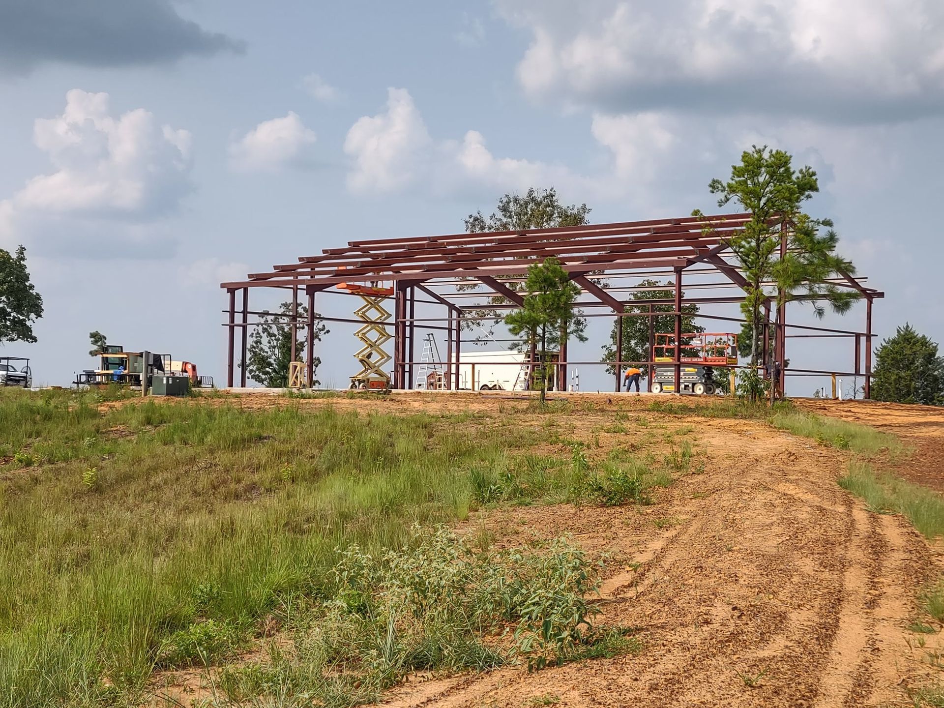 A large metal structure is being built in the middle of a field
