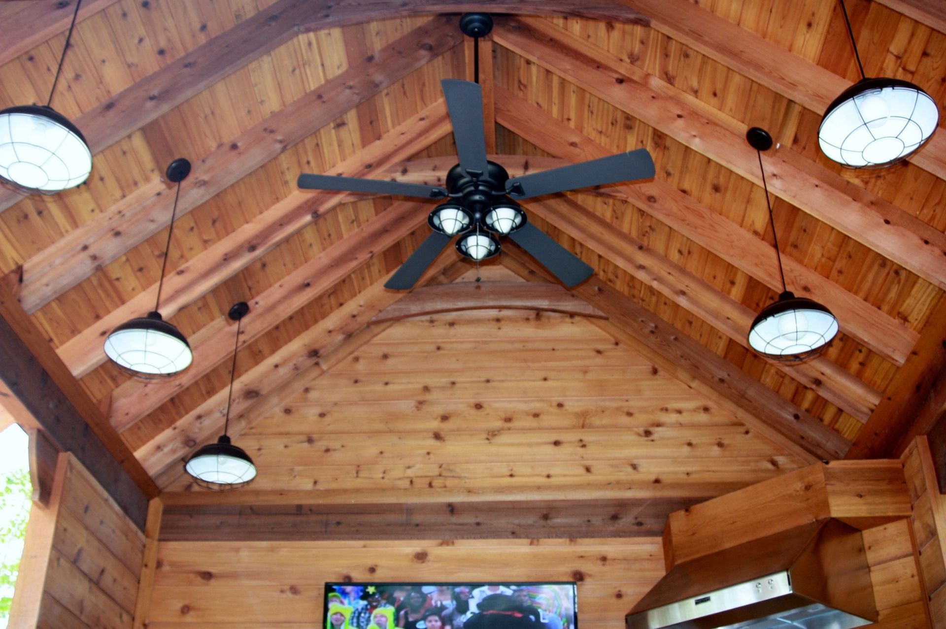 A ceiling fan is hanging from the ceiling of a wooden building
