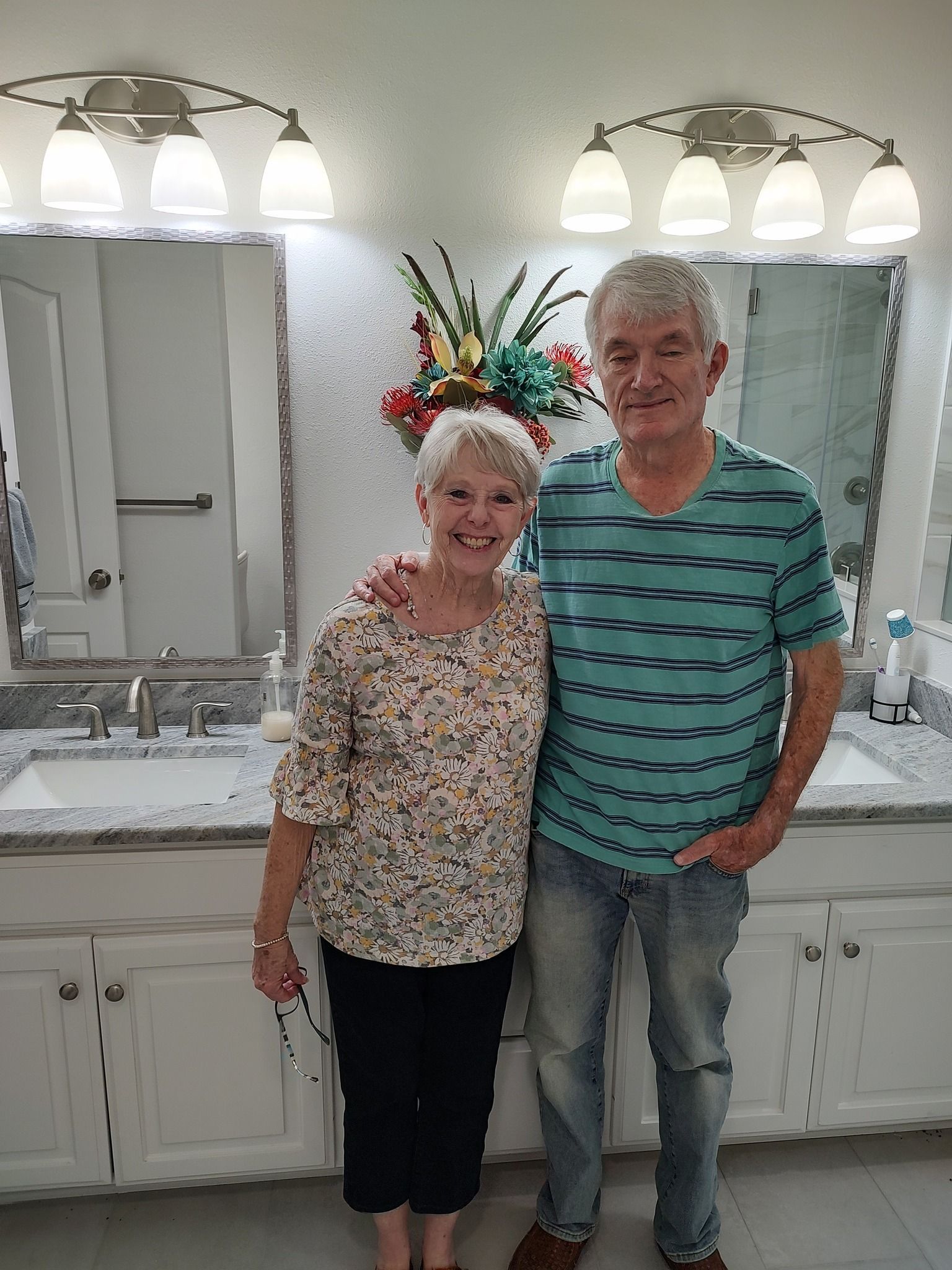 A man and a woman are posing for a picture in a bathroom.