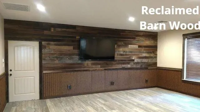 Living room with reclaimed barn wood accent wall, mounted TV, white door, and window blinds