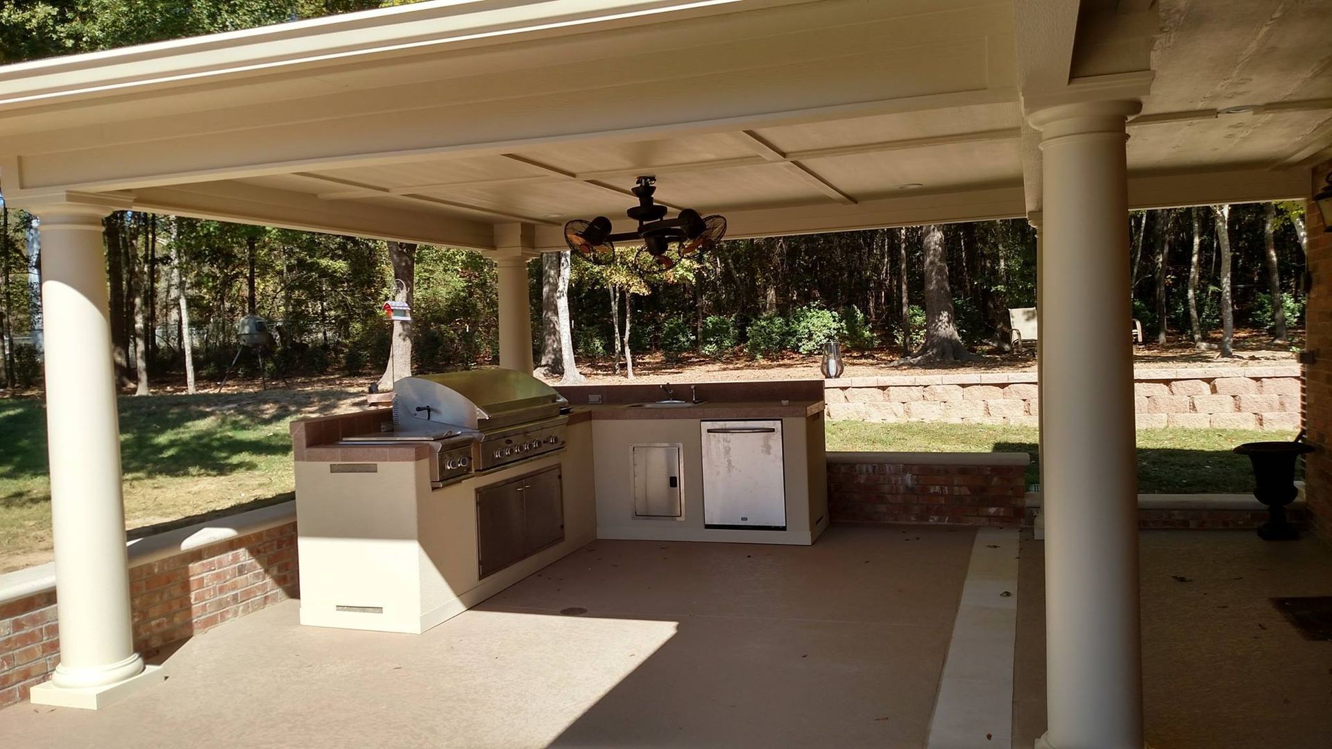 A large outdoor kitchen with a ceiling fan.