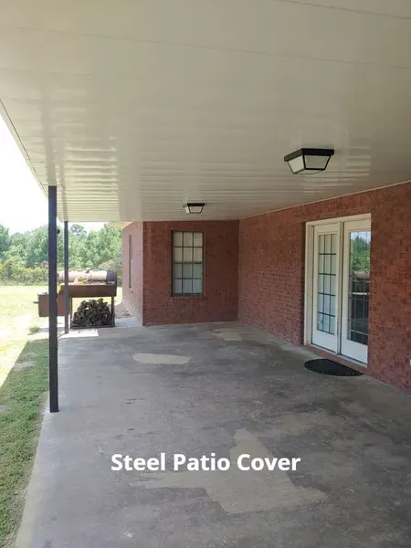 Brick patio under white steel cover beside house with glass door and windows