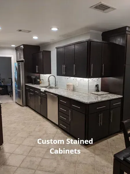 Modern kitchen with dark stained cabinets, granite countertops, and stainless appliances