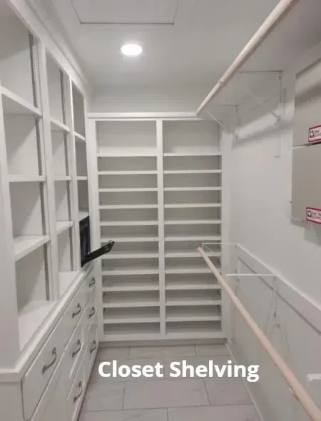 White walk-in closet with shelves, drawers, and hanging rods along both sides.