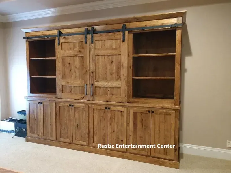 Rustic wood entertainment center with cabinets and open shelves against a beige wall