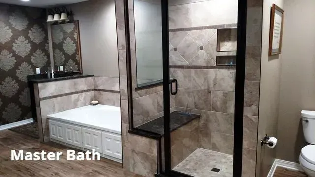 Modern master bathroom with soaking tub, glass shower, and neutral tile walls.
