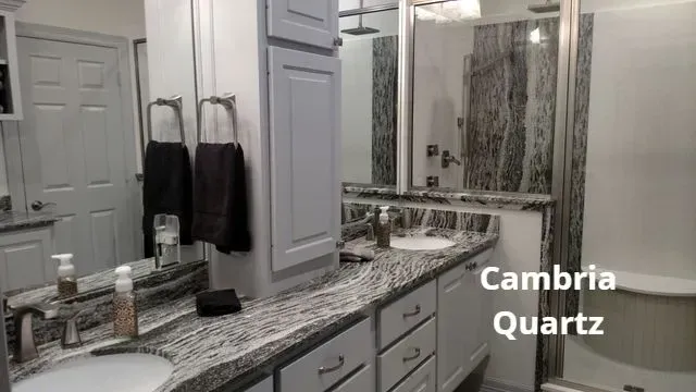 Modern bathroom vanity with marble-look Cambria quartz countertop, mirror, and hanging towels