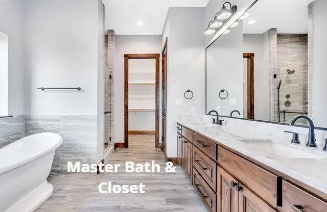 Bright master bathroom with freestanding tub, double vanity, and closet doorway, labeled “Master Bath & Closet”
