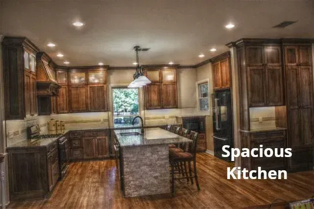 Spacious kitchen with dark wood cabinets, island, and stainless steel appliances