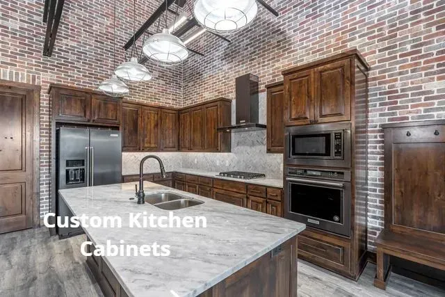Custom kitchen with wood cabinets, stainless appliances, brick walls, and a large marble island.