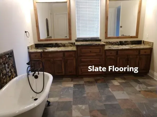 Bathroom with bathtub, double vanity, and multicolored slate tile flooring
