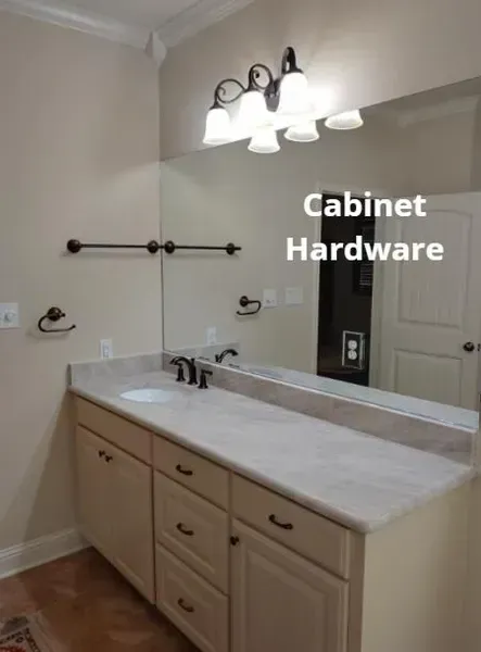 Bathroom vanity with white countertop, dark faucet, mirror, and text reading “Cabinet Hardware.”