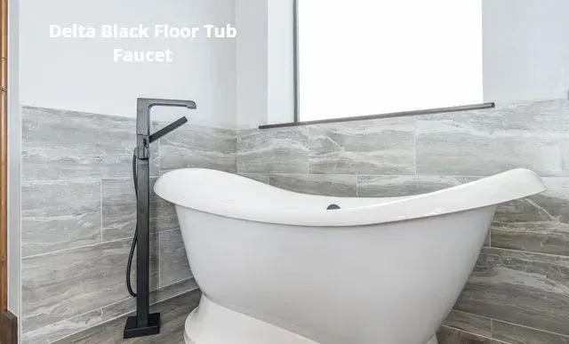 Black floor tub faucet beside a white freestanding bathtub in a modern bathroom