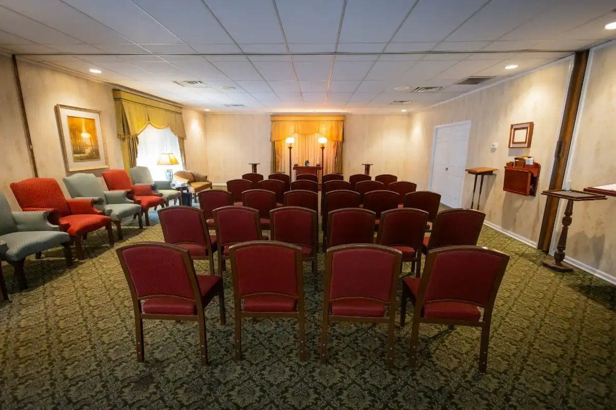 Interior of a funeral home chapel with rows of chairs and an altar area.