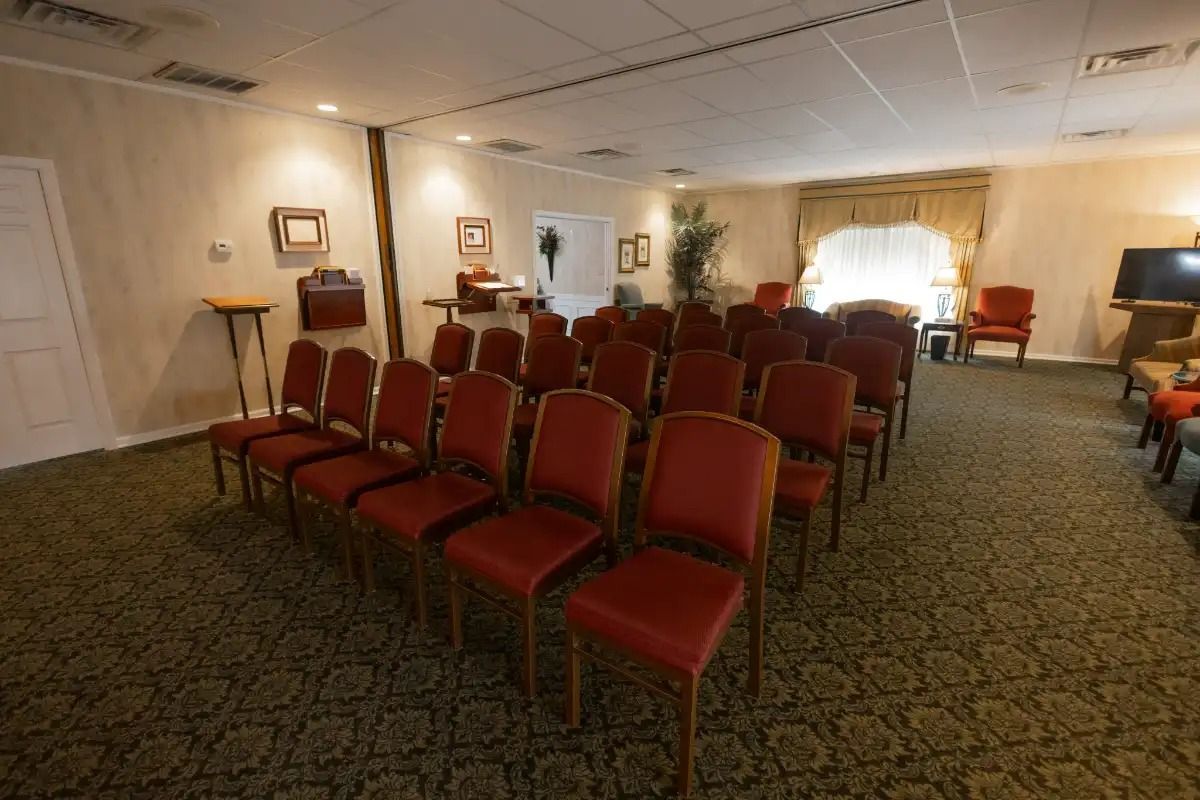 Empty room with red chairs arranged for a ceremony.