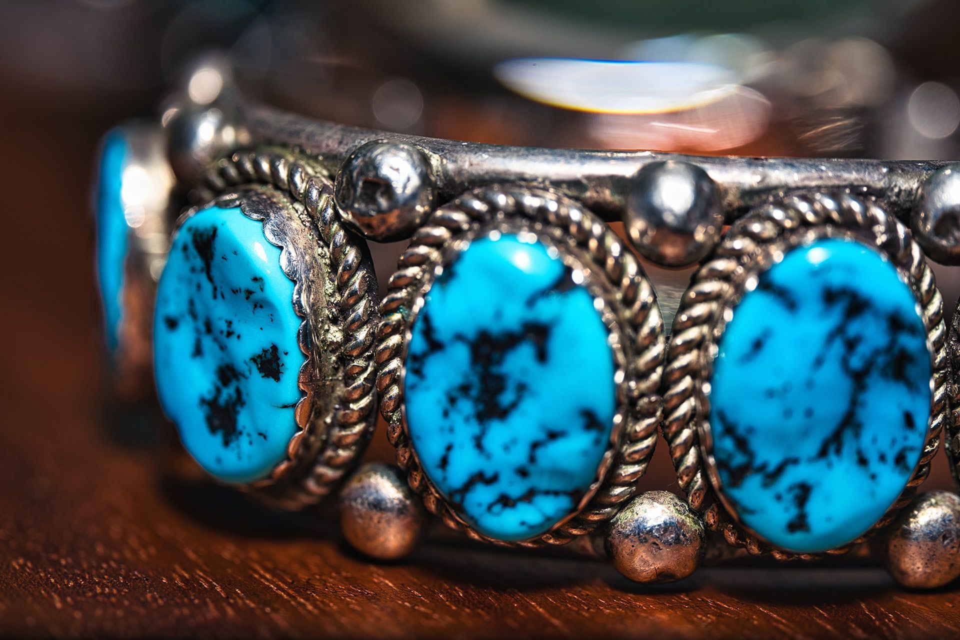 Close-up of a silver bracelet with turquoise stones and rope detailing