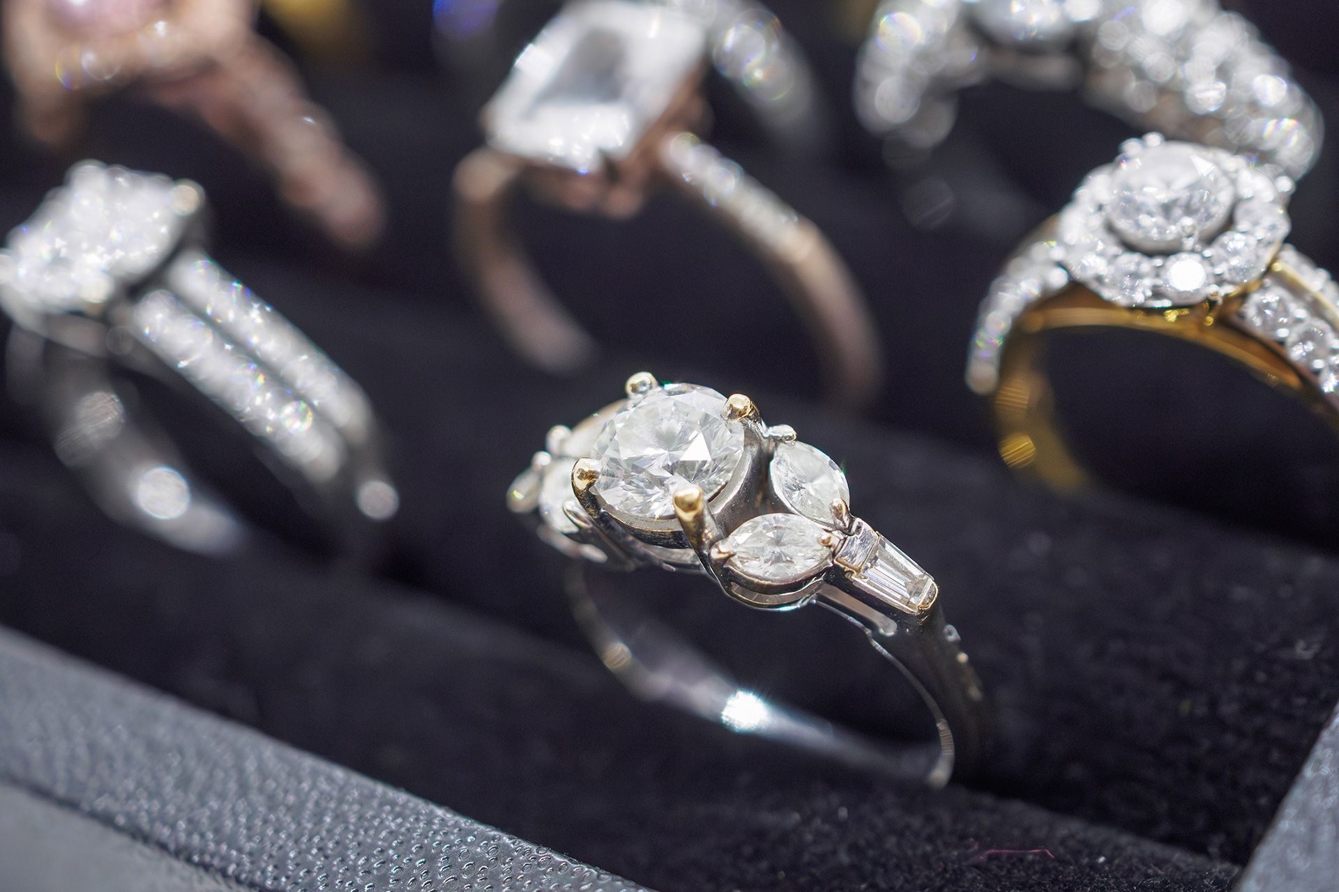 Diamond rings displayed on black velvet in a jewelry case