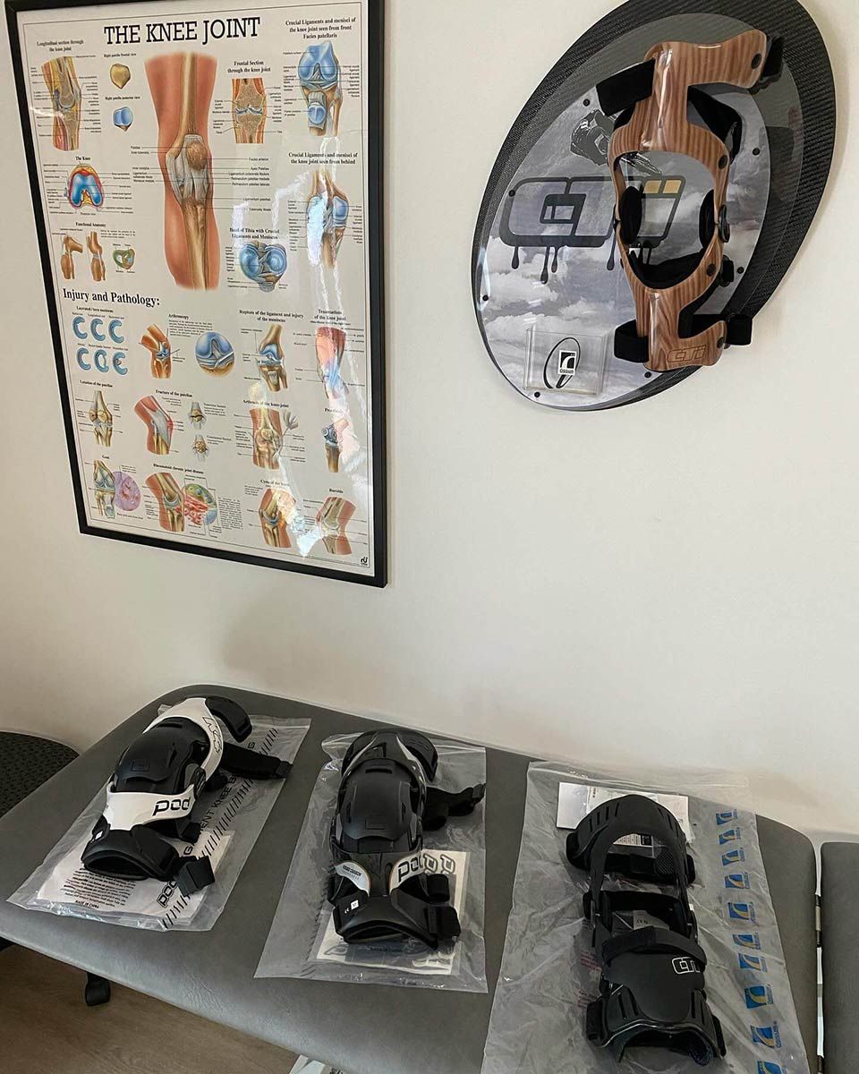 A Table With Knee Pads on It and a Poster on the Wall — Gall Bros Medical in Rockhampton, QLD