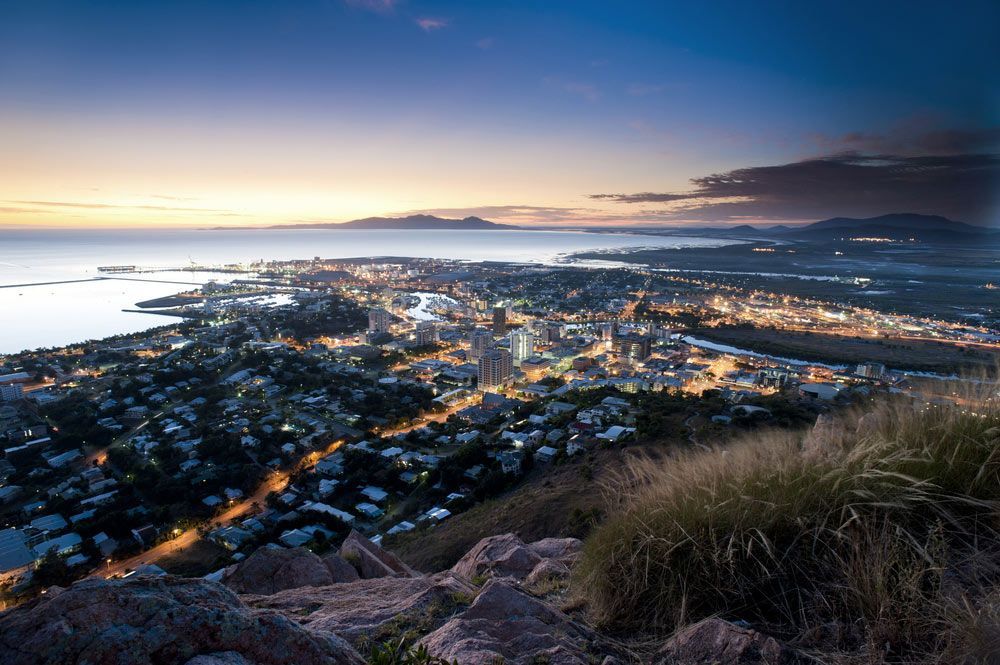 An Aerial View of a City at Night From a Mountain — Gall Bros Medical in Townsville, QLD