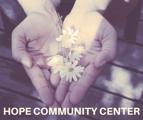 Hands holding white daisies with “HOPE COMMUNITY CENTER” text over a purple-tinted background.