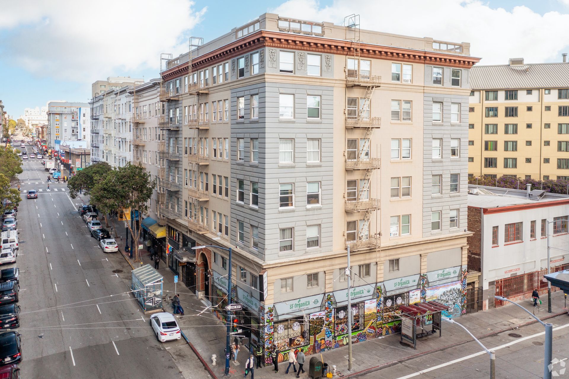 White multi-story apartment building with balconies, under a blue sky.