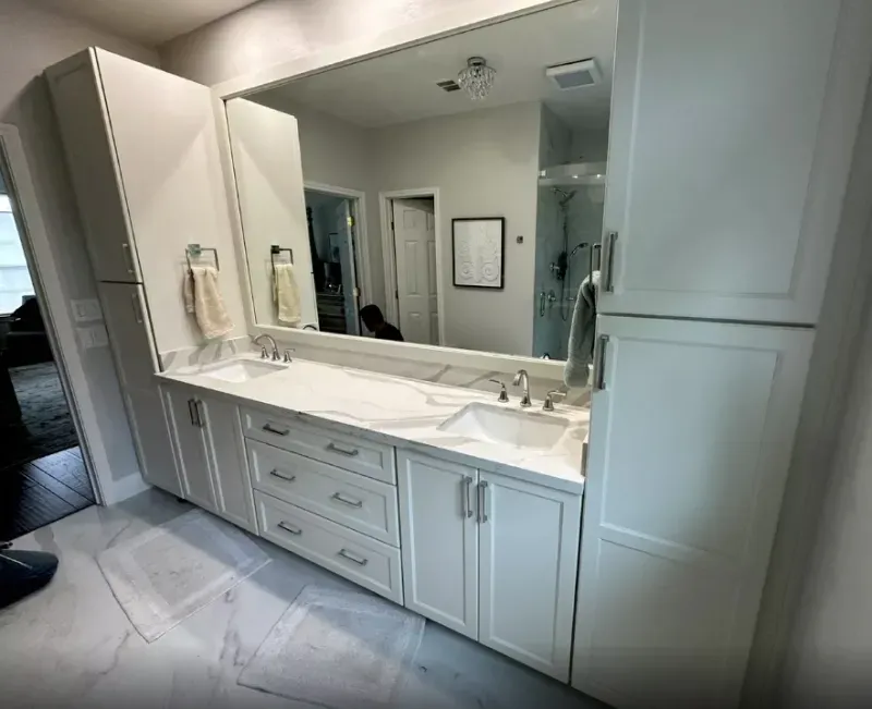 A bathroom with two sinks and a large mirror.