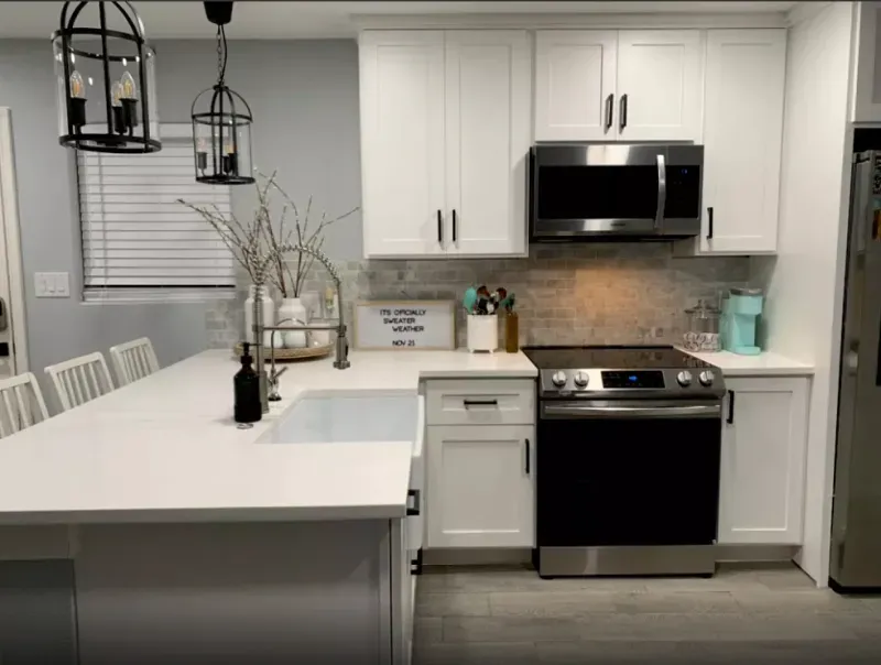 A kitchen with white cabinets and stainless steel appliances