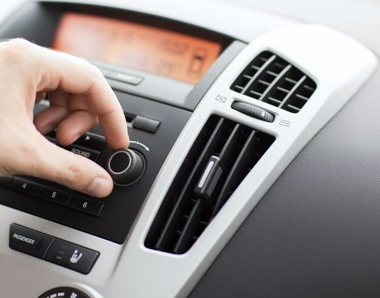 A Person Is Pressing A Button On A Car Radio — REM Auto Electrics In Wallsend, NSW