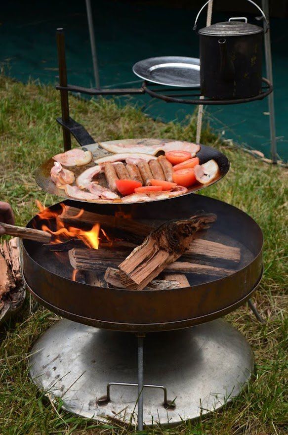 A person is cooking food over a fire pit.