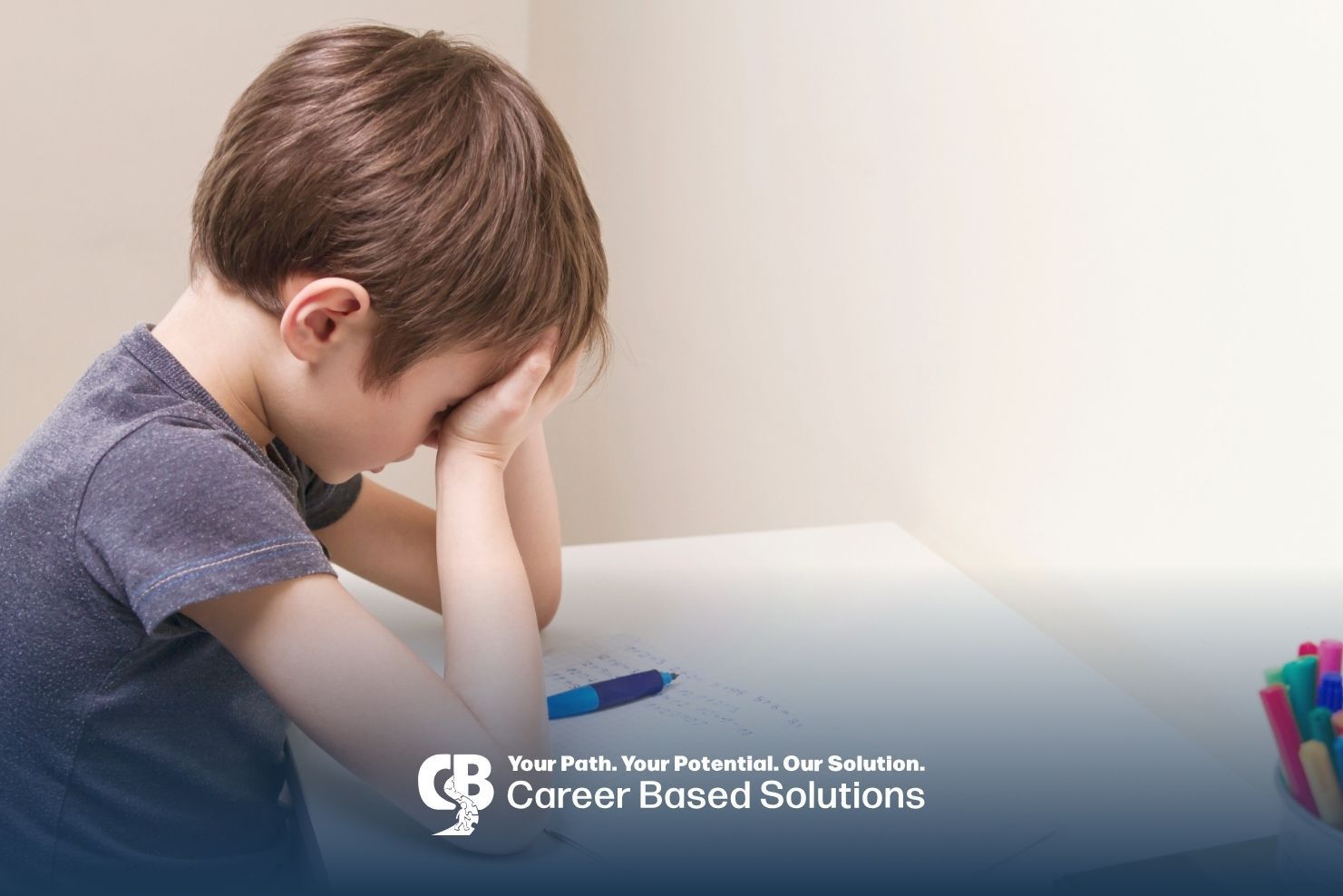 Autistic child overwhelmed at desk with schoolwork, capturing the stress of first school day.