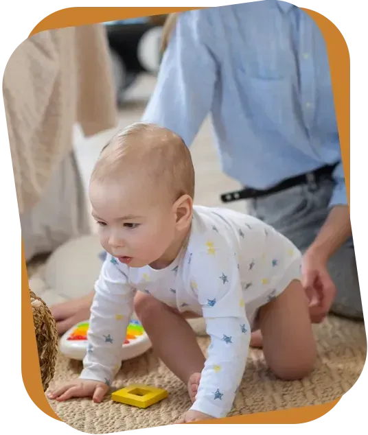 An RBT shows three flashcards featuring clothing items to a child sitting on a rug in a bright room.