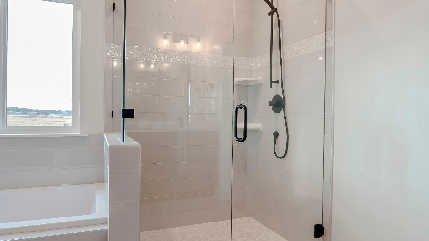 A bathroom with a walk in shower and a window.