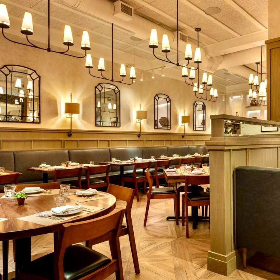 A restaurant with tables and chairs and custom glass mirrors on the wall