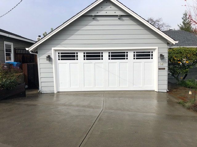 White garage with concrete driveway in a suburban home setting