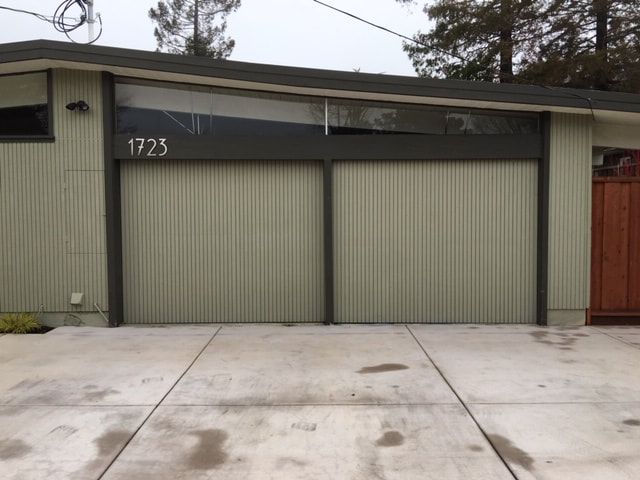 Modern gray garage with double doors and driveway, house number 1723 visible above the left door