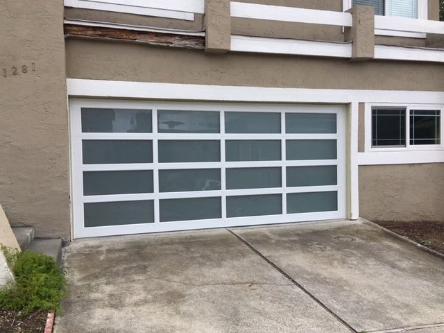 Modern house exterior with a white garage door and concrete driveway