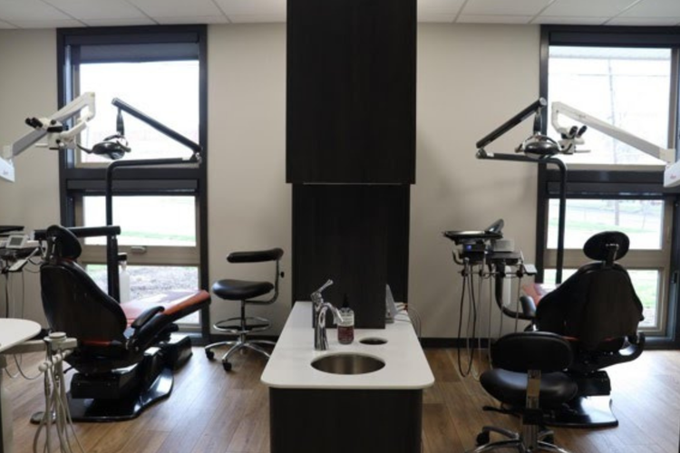A dental office with two dental chairs and a sink