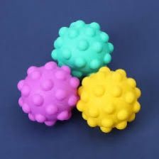 Three colorful spiky balls in turquoise, purple, and yellow against a dark blue background.