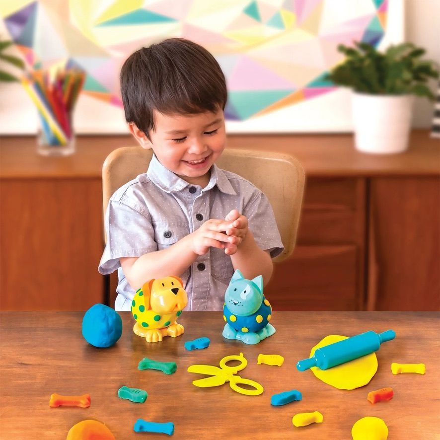 A rainbow colored pop it in the shape of a cupcake on a yellow background.