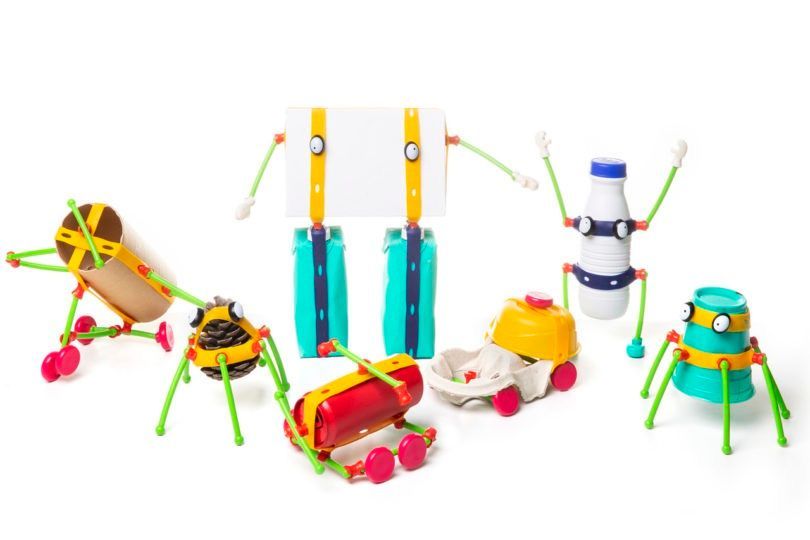 Colorful robots made from recycled materials, on a white background.